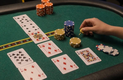 Gr&uuml;ner Blackjack-Tisch mit ausgeteilten Karten und Casino-Chips von oben