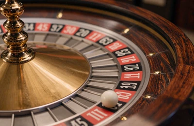 Europ&auml;isches Roulette-Rad mit einfacher Null und wei&szlig;er Kugel im warmen goldenen Licht
