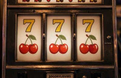 Klassischer drei-Walzen-Slotautomat mit Kirschen und goldenen Sieben im warmen Licht